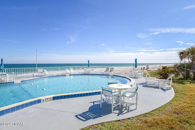 view of pool with a patio and a water view