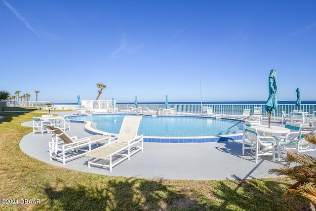 view of pool with a water view and a patio area