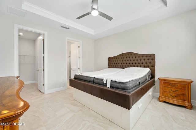 1372 Lombardi Ct, Poinciana, FL 34759 - bedroom featuring a walk in closet, ceiling fan, a tray ceiling, crown molding, and a closet