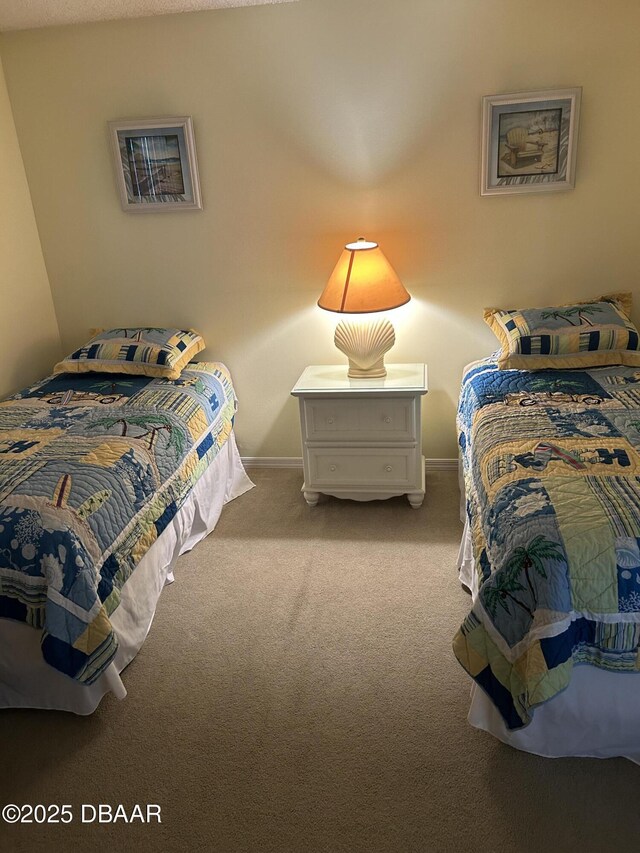 bedroom featuring light carpet and baseboards