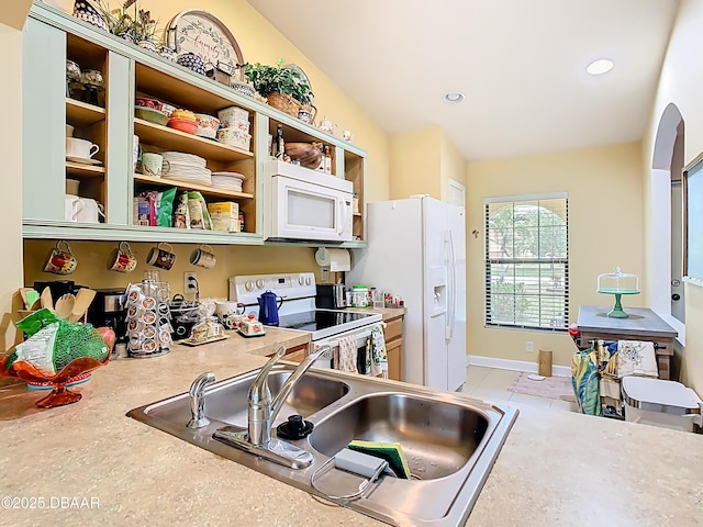 kitchen with a sink, white appliances, open shelves, recessed lighting, and light countertops