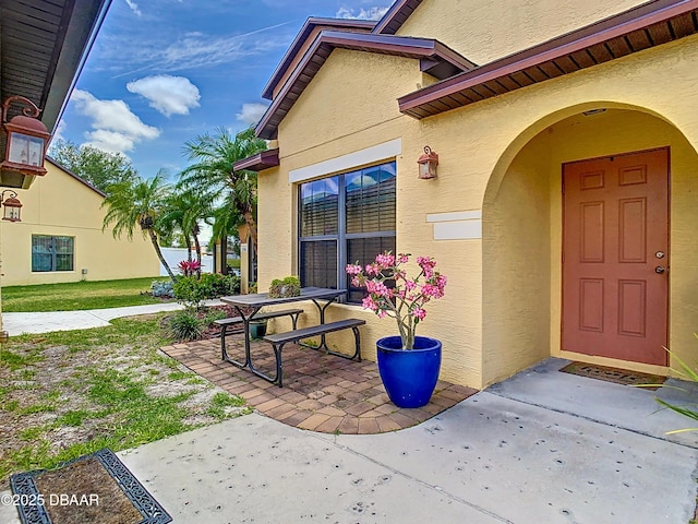 doorway to property with a patio and stucco siding