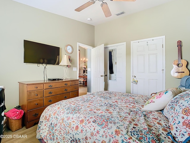 bedroom with light wood-style flooring, a closet, visible vents, ceiling fan, and vaulted ceiling