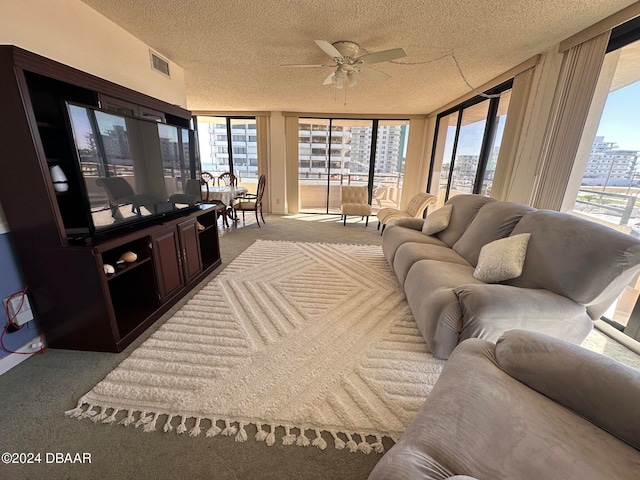 carpeted living room with a textured ceiling, floor to ceiling windows, and ceiling fan