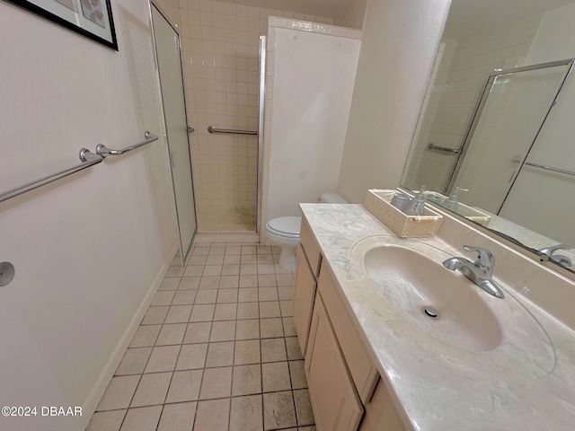 bathroom featuring tile patterned flooring, vanity, a shower with door, and toilet