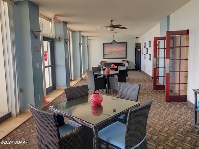 carpeted dining space with ceiling fan and french doors