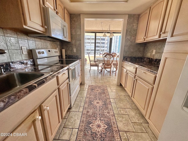 kitchen with light brown cabinetry, decorative light fixtures, white appliances, and sink