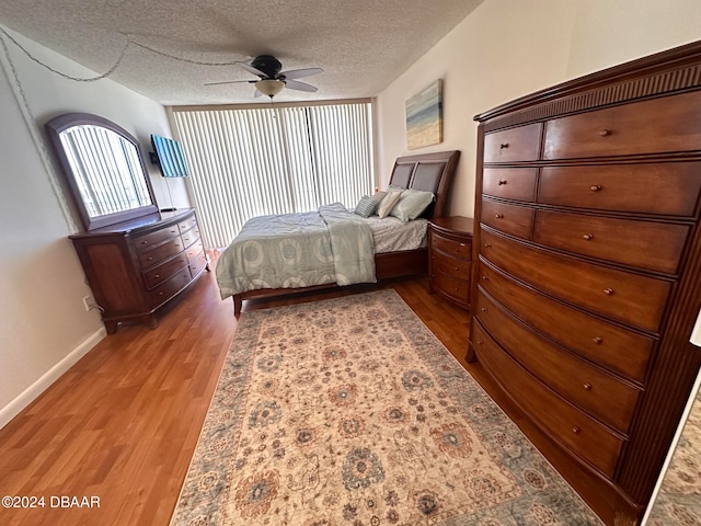 bedroom featuring wood-type flooring, a textured ceiling, and ceiling fan