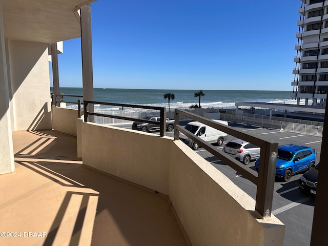 balcony featuring a water view and a view of the beach