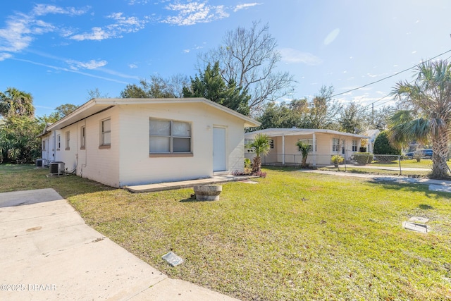 view of front of property featuring cooling unit and a front yard