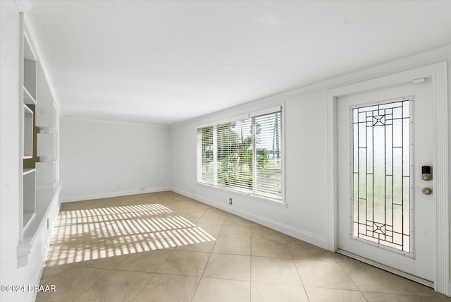 tiled entrance foyer featuring plenty of natural light and crown molding