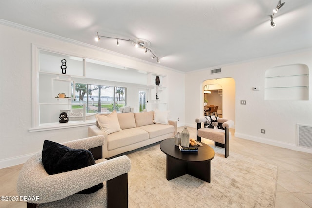 tiled living room with crown molding, track lighting, and built in shelves