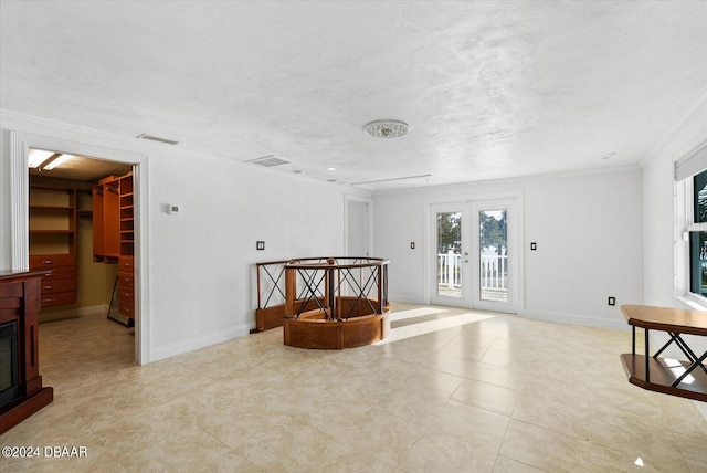 unfurnished room with french doors, a textured ceiling, and ornamental molding