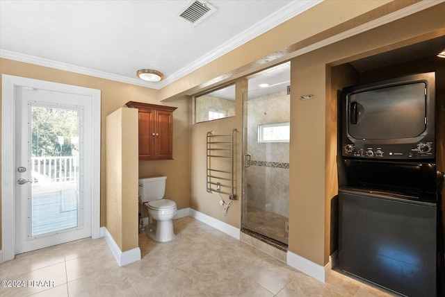 bathroom featuring tile patterned flooring, tiled shower, toilet, and ornamental molding