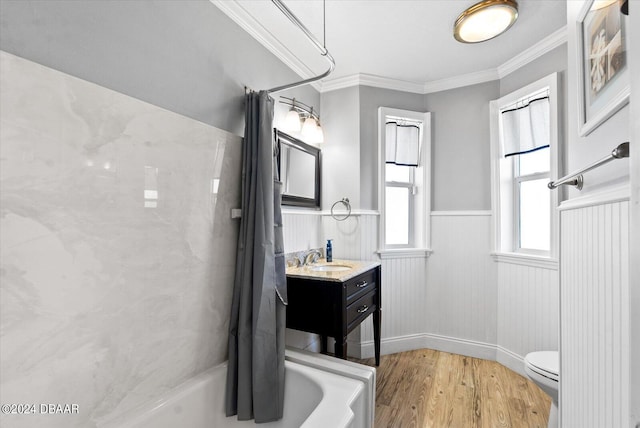 full bathroom with shower / tub combo with curtain, hardwood / wood-style flooring, crown molding, vanity, and toilet