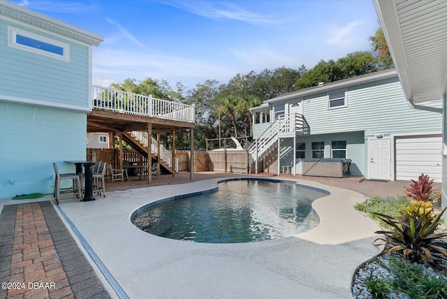 view of swimming pool featuring a patio, a hot tub, and a deck