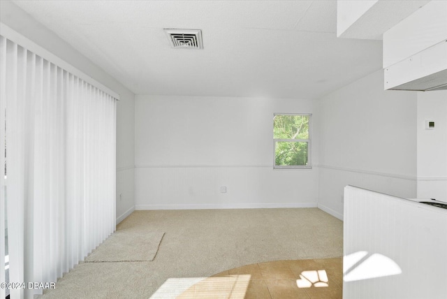 carpeted spare room with a textured ceiling