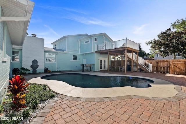 view of swimming pool with french doors, a patio, and a deck