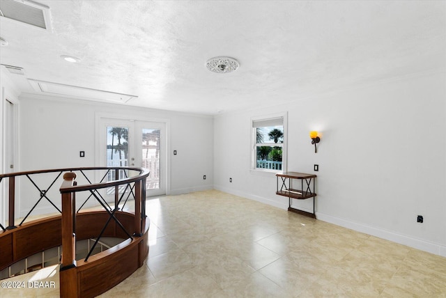 empty room with a textured ceiling and french doors