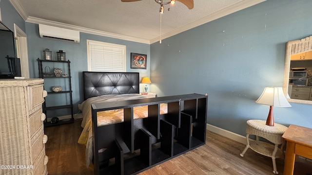 bedroom with ornamental molding, a wall unit AC, ceiling fan, a textured ceiling, and hardwood / wood-style floors