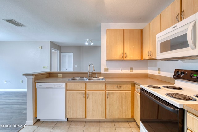 kitchen featuring sink, light brown cabinetry, a textured ceiling, light tile patterned floors, and white appliances