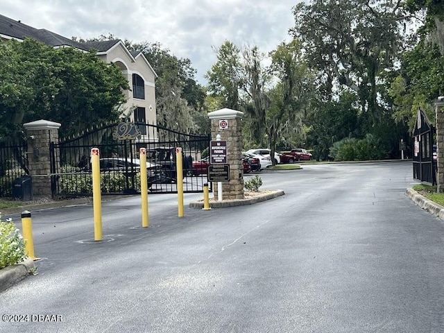 940 Village Trl Unit 2-207, Port Orange, FL 32127 - view of asphalt street with curbs and a gated entry