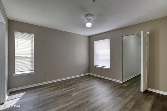 940 Village Trl Unit 2-207, Port Orange, FL 32127 - spare room featuring plenty of natural light, dark wood finished floors, ceiling fan, and baseboards