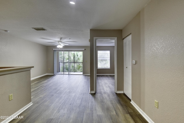 940 Village Trl Unit 2-207, Port Orange, FL 32127 - spare room with dark wood-style floors, baseboards, a textured wall, and ceiling fan