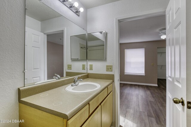 940 Village Trl Unit 2-207, Port Orange, FL 32127 - bathroom featuring wood finished floors, a textured wall, vanity, and baseboards