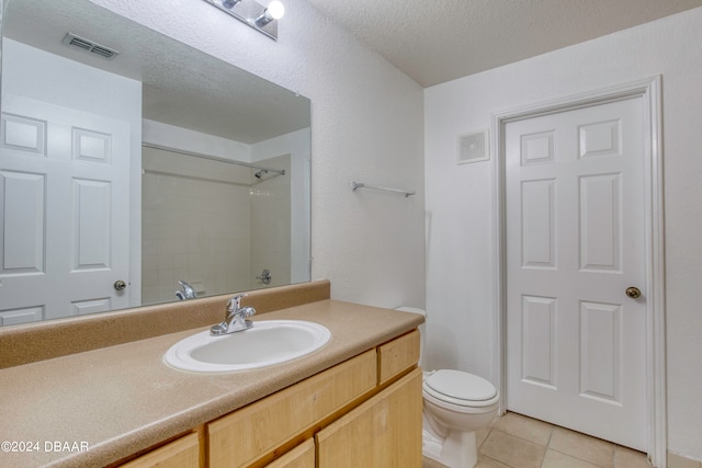 bathroom with toilet, tile patterned floors, a textured ceiling, vanity, and walk in shower