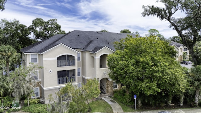 940 Village Trl Unit 2-207, Port Orange, FL 32127 - view of front of house with stucco siding, roof with shingles, and a balcony