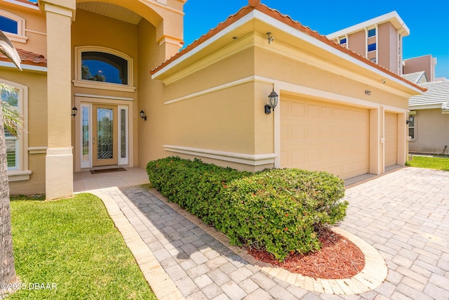4427 S Atlantic Ave, Ponce Inlet, FL 32127 - property entrance with stucco siding, a tiled roof, and decorative driveway