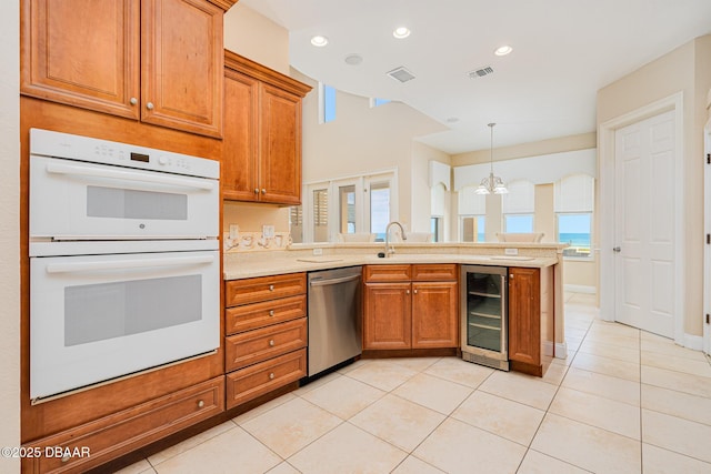 4427 S Atlantic Ave, Ponce Inlet, FL 32127 - kitchen with beverage cooler, double oven, stainless steel dishwasher, a peninsula, and light tile patterned floors