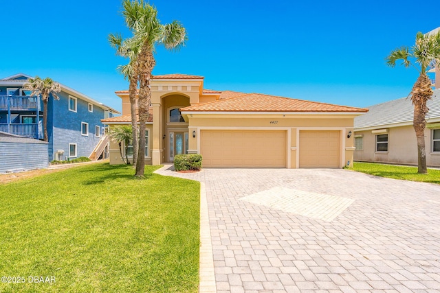 4427 S Atlantic Ave, Ponce Inlet, FL 32127 - mediterranean / spanish-style home featuring an attached garage, decorative driveway, a front yard, stucco siding, and a tiled roof