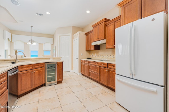 4427 S Atlantic Ave, Ponce Inlet, FL 32127 - kitchen featuring freestanding refrigerator, beverage cooler, stainless steel dishwasher, under cabinet range hood, and a sink