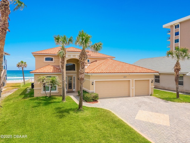 4427 S Atlantic Ave, Ponce Inlet, FL 32127 - mediterranean / spanish-style house with decorative driveway, an attached garage, a front lawn, and stucco siding
