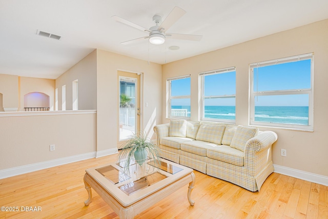 4427 S Atlantic Ave, Ponce Inlet, FL 32127 - living room with wood finished floors, baseboards, a ceiling fan, and a water view
