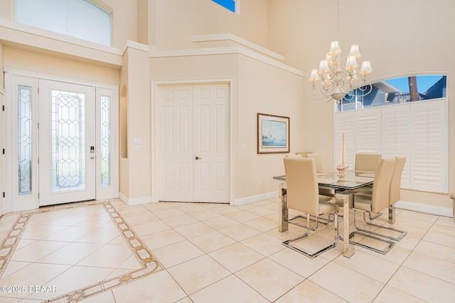 4427 S Atlantic Ave, Ponce Inlet, FL 32127 - dining area with a towering ceiling, a chandelier, baseboards, and light tile patterned floors