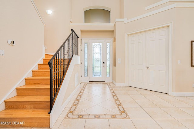 4427 S Atlantic Ave, Ponce Inlet, FL 32127 - entryway with light tile patterned floors, baseboards, stairway, and a high ceiling