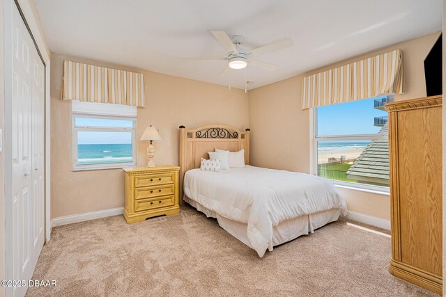 4427 S Atlantic Ave, Ponce Inlet, FL 32127 - carpeted bedroom with multiple windows, a closet, baseboards, and ceiling fan