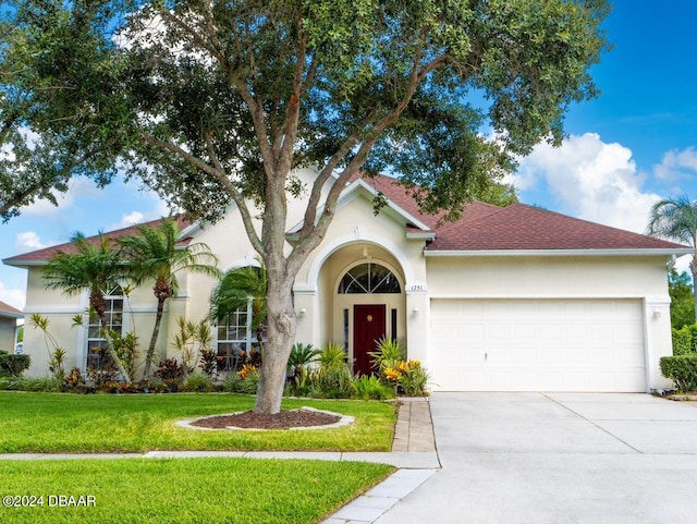 mediterranean / spanish-style house featuring a front lawn and a garage