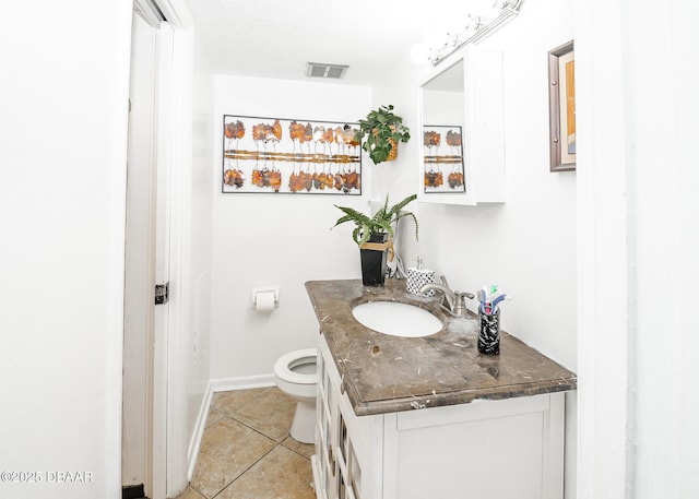 bathroom featuring vanity, tile patterned floors, and toilet