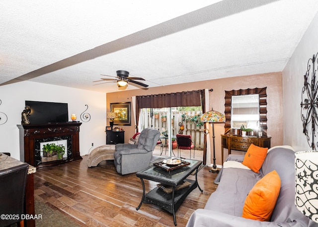 living room featuring a textured ceiling, wood-type flooring, and ceiling fan