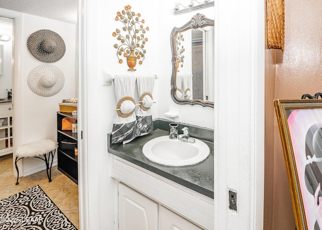 bathroom with tile patterned flooring, vanity, and a textured ceiling