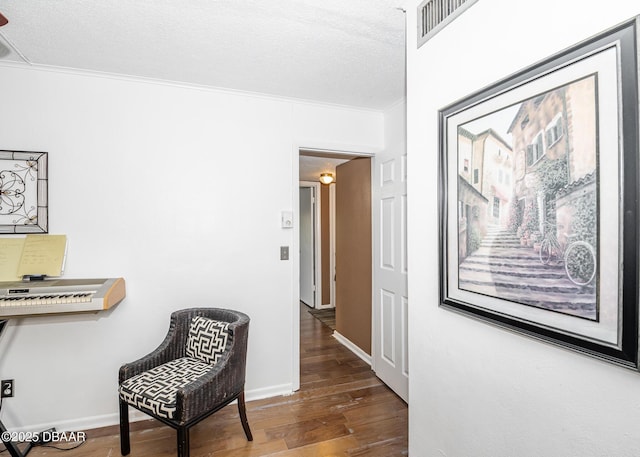 hall featuring hardwood / wood-style flooring, crown molding, and a textured ceiling