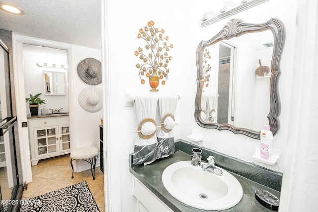 bathroom featuring tile patterned floors, a textured ceiling, and vanity