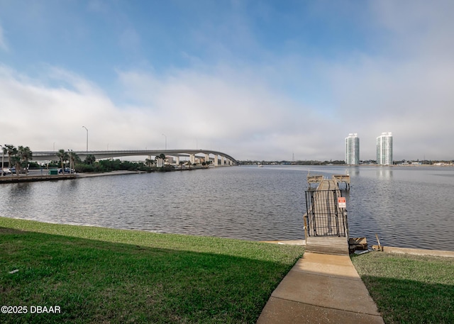 view of dock with a water view and a lawn