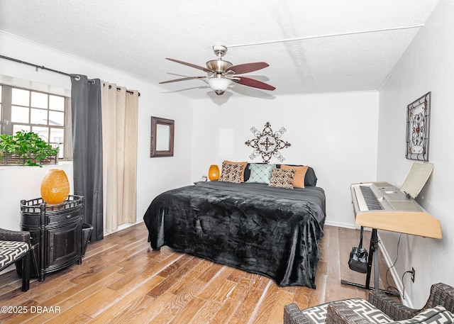 bedroom featuring ceiling fan, a textured ceiling, and light wood-type flooring