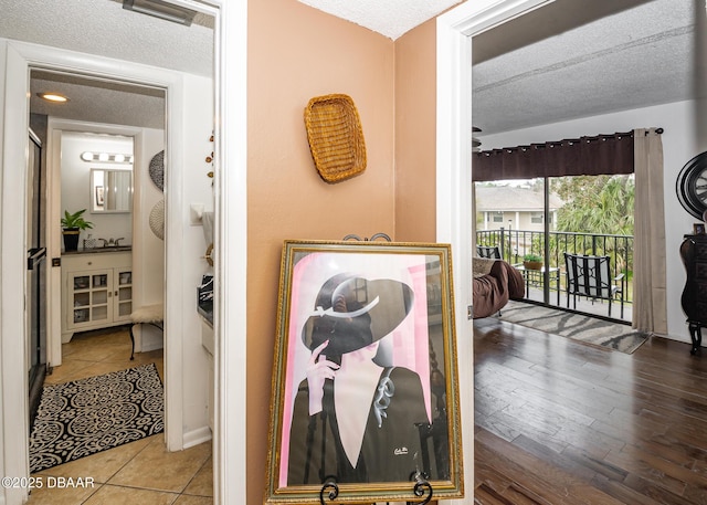 hall with hardwood / wood-style floors and a textured ceiling