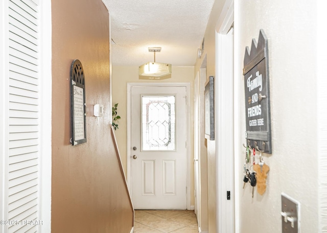 entryway with light tile patterned floors and a textured ceiling